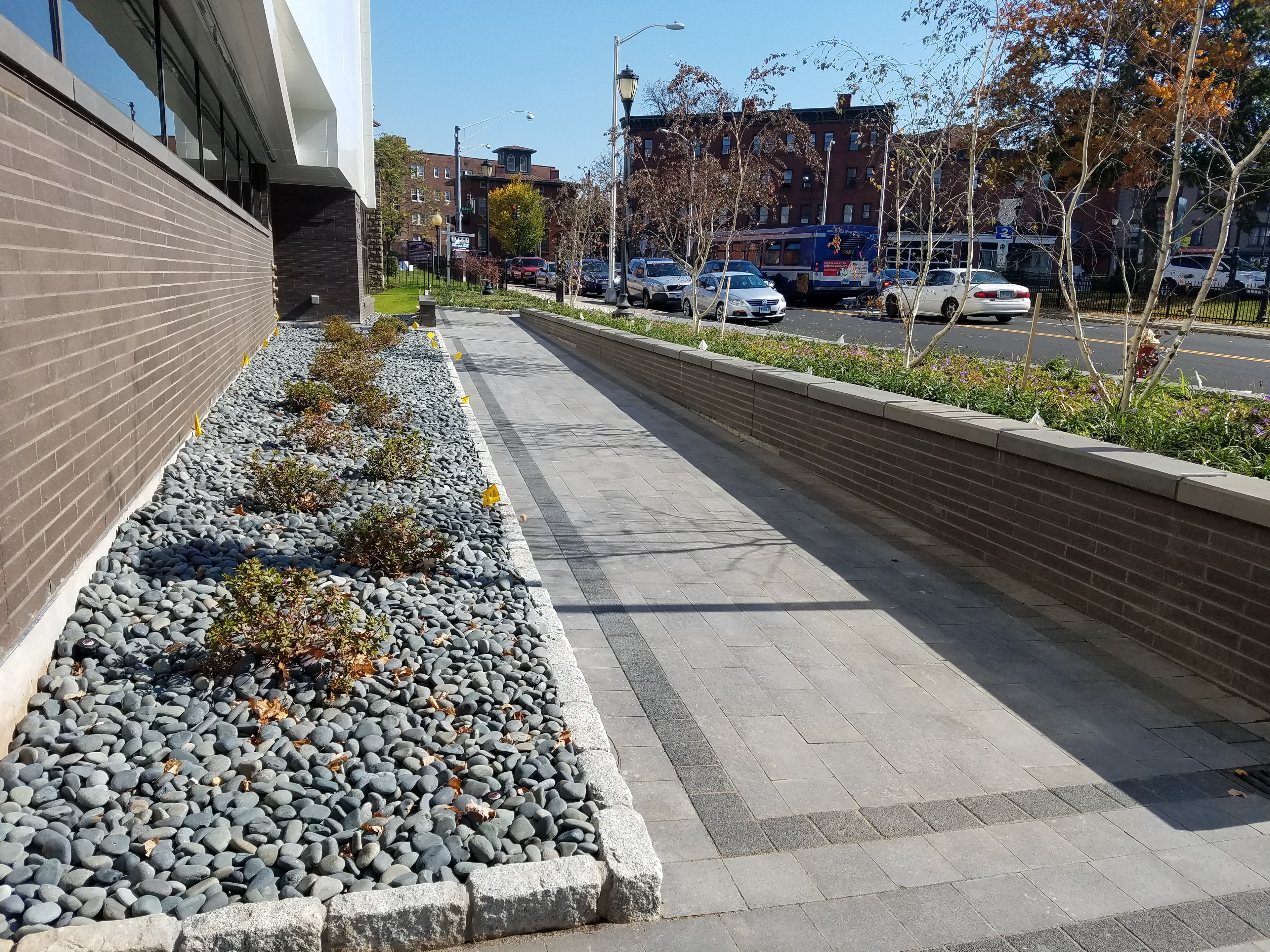 Commercial walkway planter bed filled with black Mexican beach pebbles, Hartford CT hospital