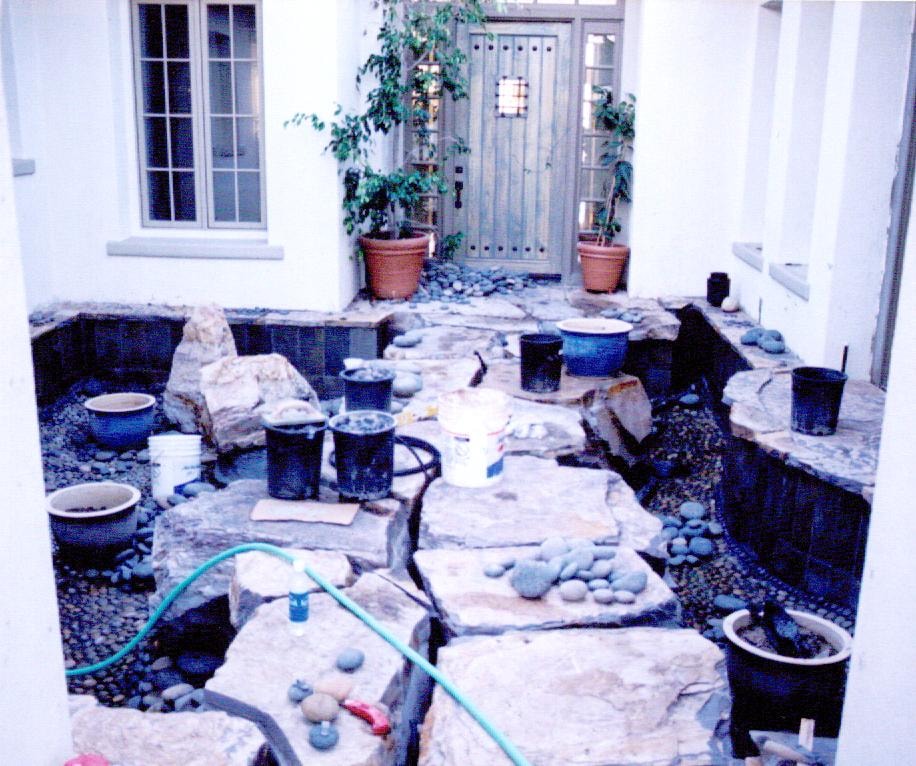 Koi pond construction with black Mexican beach pebbles lining the pond floor